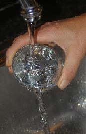 Water poring into drinking glass